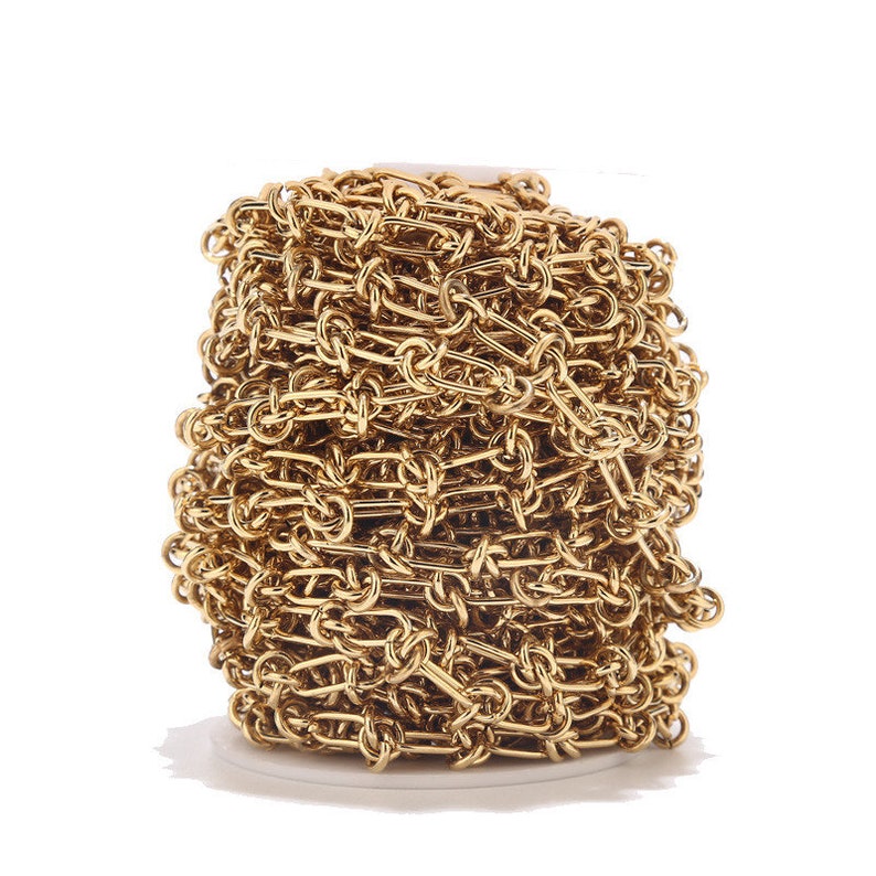 May include: A spool of gold-colored chain, likely for jewelry making. The chain is made of small, linked loops.