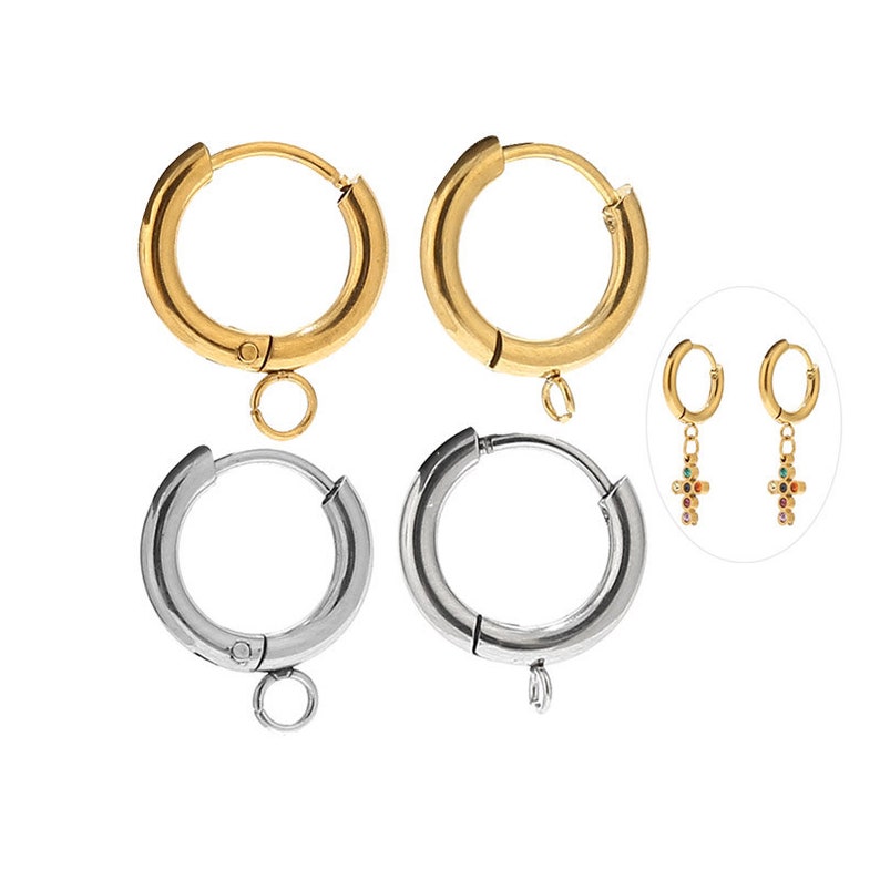 May include: Two pairs of hoop earrings, one pair in gold and one pair in silver. Each pair has a small loop at the bottom for attaching a charm. The charms are not included.