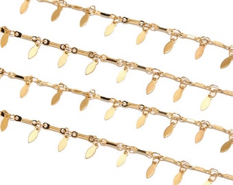 May include: Four strands of gold chain with small leaf-shaped charms hanging from each link.