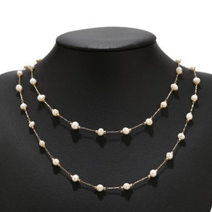 Puede incluir: Un delicado collar de cadena dorada con peque&ntilde;as perlas blancas. El collar est&aacute; en capas, creando un look elegante y sofisticado.