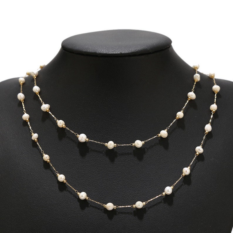 Puede incluir: Un delicado collar de cadena dorada con peque&ntilde;as perlas blancas. El collar est&aacute; en capas, creando un look elegante y sofisticado.