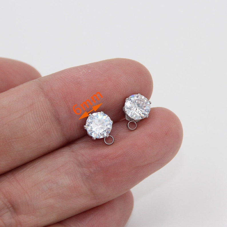 K&ouml;nnte beinhalten: Ein Paar silberne Ohrring-Verschl&uuml;sse mit einem 6 mm gro&szlig;en, klaren, runden Kristall.
