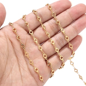 May include: Gold chain with a delicate, open circle design. The chain is made of metal and has a polished finish.