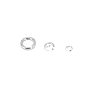 May include: Three silver jump rings of different sizes. The largest ring is about 2.5 cm in diameter, the middle ring is about 1.25 cm in diameter, and the smallest ring is about 0.6 cm in diameter.