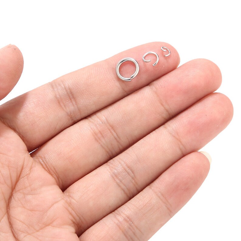 May include: Three silver jump rings of different sizes. The rings are smooth and shiny.