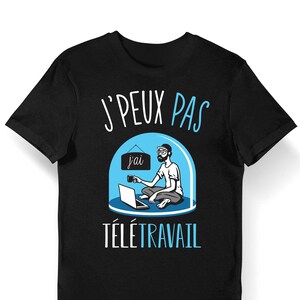 Könnte beinhalten: Schwarzes T-Shirt mit einer blauen und weißen Illustration einer Person, die an einem Laptop in einer Kuppel arbeitet. Der Text "J'PEUX PAS" und "TÉLÉTRAVAIL" ist auf dem Shirt aufgedruckt.