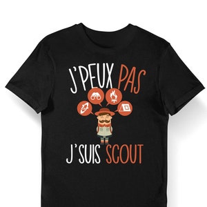 Può includere: Maglietta nera con testo bianco che recita "J'PEUX PAS J'SUIS SCOUT". Il testo è circondato da immagini di cartoni animati di una bussola, un binocolo, un falò e una tenda.
