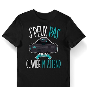 Può includere: T-shirt nero con una grafica di una tastiera e un mouse. Il testo sulla maglietta recita "J'PEUX PAS MON CLAVIER M'ATTEND".