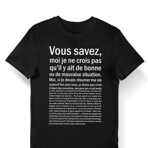May include: Black t-shirt with white text that reads "Vous savez, moi je ne crois pas qu'il y ait de bonne ou de mauvaise situation. Moi, si je devais résumer ma vie aujourd'hui avec vous, je dirais que c'est d'abord des rencontres, des gens qui m'ont tendu la mais, peut-être à un moment où je ne pouvais pas, où j'étais seul chez moi. Et c'est assez ceux de se dire que les hasards, les rencontres forget une destinée... Parce que quand on a le goût de la chose, quand on a le goût de la chose bien faite, le beau geste, parfois on ne trouve pas l'interlocuteur en face je dirais, le miroir qui vous aide à avancer. Alors ça n'est pas mon cas, comme je disais là. puisque mol au contraire, j'ai pu et je dis merci à la vie, je lui dis merci, je chante la vie, je danse la vie... je ne suis qu'amour ! Et finalement, quand beaucoup de gens aujourd'hui me disent Mais comment fais-tu pour avoir cette humanité?, et bien je leur réponds simplement, je leur dis que c'est ce goût de l'amour ce goût donc qui m'a poussé aujourd'hui à entreprendre une construction mécanique, mais demain qui sait? Peut-être simplement à me mettre au service de la communauté, à faire le don, le don de sol..."