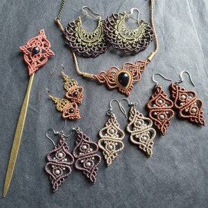 May include: A set of handmade jewelry featuring a variety of styles, including a necklace with a black stone, earrings with brown and silver beads, and a hair stick with a brown and black design.