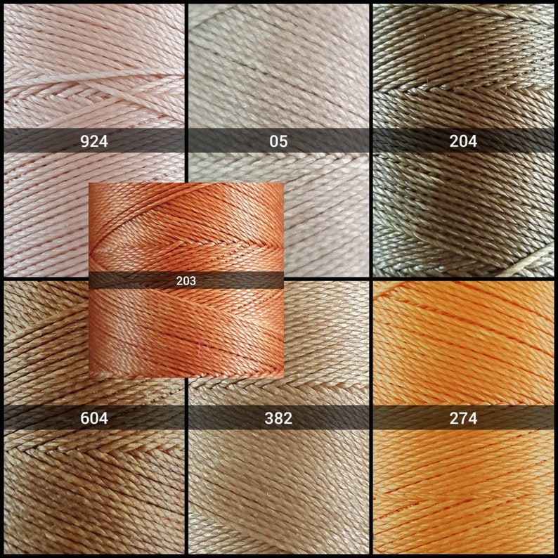 May include: Nine spools of thread in various shades of peach, orange, and brown. The spools are labeled with numbers: 924, 05, 204, 203, 604, 382, and 274.