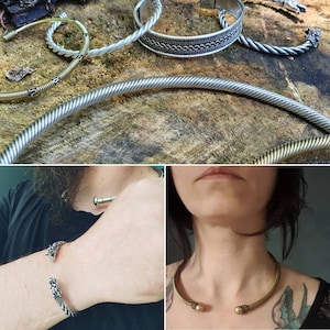 May include: A set of four silver and brass bracelets with a braided design. Two of the bracelets have a dragon head design at the end. The bracelets are shown on a wooden surface and on a person's wrist.