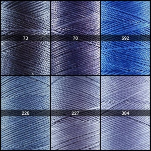 May include: Nine spools of thread in various shades of blue. The spools are labeled with numbers: 73, 70, 692, 226, 227, and 384.