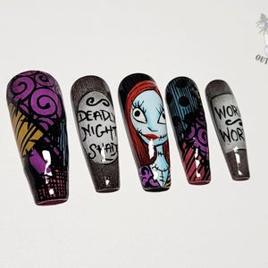 Puede incluir: Un juego de cinco u&ntilde;as postizas con dise&ntilde;os pintados a mano inspirados en Pesadilla antes de Navidad. Las u&ntilde;as muestran espirales moradas, una etiqueta que dice DEADLY NIGHT SHADE, un retrato de Sally, rayas negras y azules, y el texto WORM WORT.