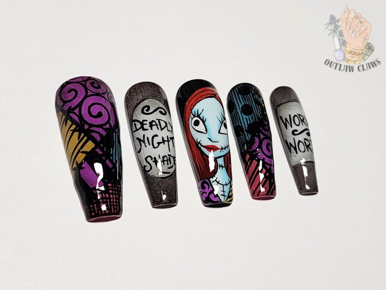 Puede incluir: Un juego de cinco u&ntilde;as postizas con dise&ntilde;os pintados a mano inspirados en Pesadilla antes de Navidad. Las u&ntilde;as muestran espirales moradas, una etiqueta que dice DEADLY NIGHT SHADE, un retrato de Sally, rayas negras y azules, y el texto WORM WORT.