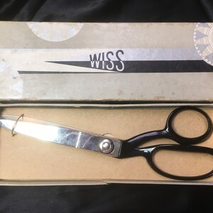 May include: Vintage WISS shears in their original box. The shears have shiny silver blades and black handles. The box is beige with the word "WISS" in white and black stripes. The box is open, revealing the shears.
