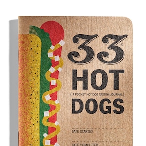 以下が含まれることがあります： 表紙にホットドッグのイラストが描かれた茶色のノート。ノートのタイトルは「33 Hot Dogs (A Pocket Hot Dog Tasting Journal)」で、「開始日」と「完了日」の記入欄があります。