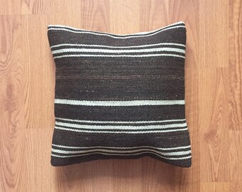May include: A brown and white striped throw pillow with a woven texture.