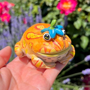 Handmade Polymer Clay Cute Yellow Orange Pacman Frog with Blue Flower Hat Figurine | Colorful Round Happy Amphibian Pet Collectible