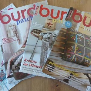 Op de afbeelding: Een stapel van vier tijdschriften met het woord "burda" in grote rode letters bovenaan. De tijdschriften tonen afbeeldingen van naaiprojecten en de tekst "patchwork". De covers hebben verschillende ontwerpen en tekst in het Duits.
