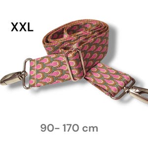 Könnte beinhalten: Rosa-braunes, gemustertes, verstellbares Band mit silbernen Verschlüssen. Das Band ist mit "XXL" gekennzeichnet und misst 90-170 cm.