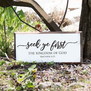 Może przedstawiać: Biały drewniany znak z czarnym tekstem, kt&oacute;ry brzmi "seek ye first the kingdom of god Matthew 6:33".