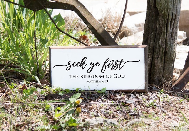 Może przedstawiać: Biały drewniany znak z czarnym tekstem, kt&oacute;ry brzmi "seek ye first the kingdom of god Matthew 6:33".