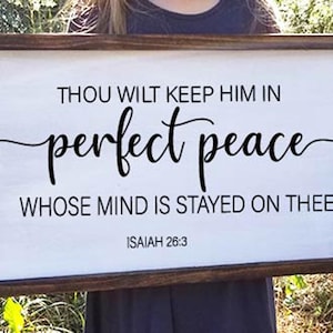May include: A wooden sign with a white background and black text. The text reads "Thou wilt keep him in perfect peace whose mind is stayed on thee. Isaiah 26:3".