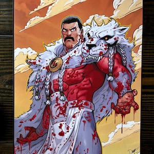 Op de afbeelding: Stripboek kunstafdruk van een gespierde figuur in een rode en witte outfit, bedekt met bloed. Hij draagt een witte vachtmantel met een wolvenkop en gevlochten haar. De achtergrond is een oranje lucht met wolken.