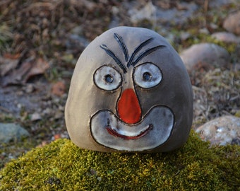 gray stone with a funny clay face