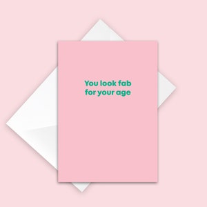 May include: Pink greeting card with the text "You look fab for your age" in green.