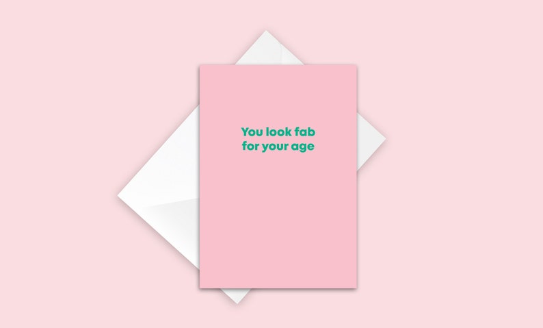 May include: Pink greeting card with the text "You look fab for your age" in green.
