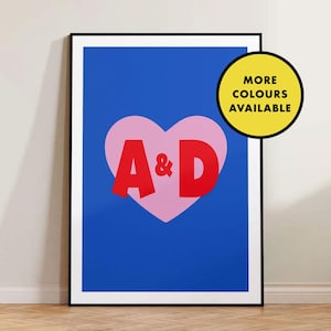 May include: A blue and pink heart-shaped graphic with the letters A & D in red. The text "More Colours Available" is in a yellow circle.