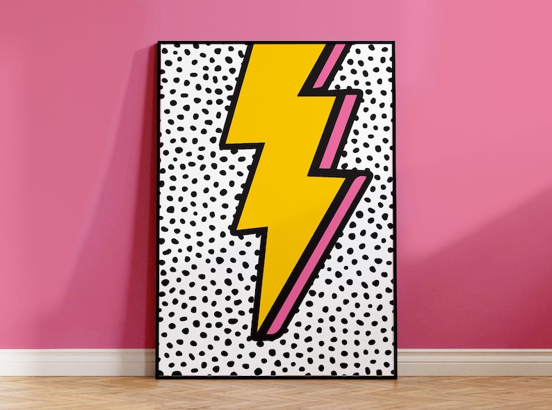 Pu&ograve; includere: Un fulmine giallo con un contorno rosa su uno sfondo bianco con pois neri. L'immagine &egrave; incorniciata in nero.