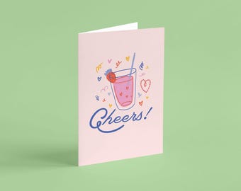 May include: A pink greeting card with a cartoon illustration of a glass of pink lemonade with a strawberry on top and a straw. The text "Cheers!" is written in blue below the glass.