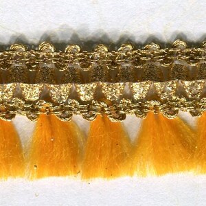 May include: Gold trim with a fringe of yellow tassels. This trim is perfect for adding a touch of elegance to any project.