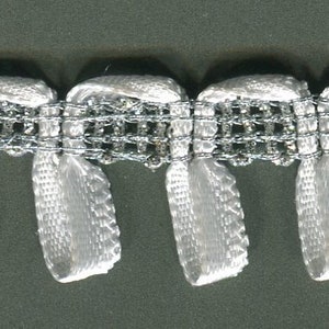 May include: White fringe trim with a delicate, woven pattern. The fringe is made of a soft, silky material and has a subtle sheen.