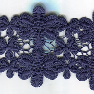 May include: A close-up of a navy blue lace trim with a delicate floral pattern.