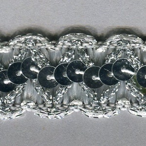 May include: Silver trim with a row of silver sequins. The trim has a scalloped edge.