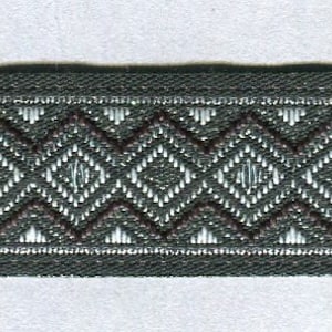 Könnte beinhalten: Nahaufnahme eines grün-weißen gemusterten Besatzes mit einem Rautenmuster. Der Besatz ist mit einem braunen Faden gewebt.