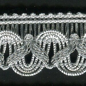 May include: Silver and white trim with a scalloped edge. The trim has a repeating pattern of small loops.