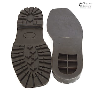 May include: A pair of brown leather shoe soles. The sole on the left has a textured tread pattern. The sole on the right has a smooth surface with a grid pattern and the text "ART - 1136 39/40".