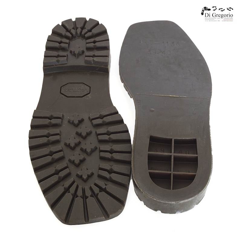 May include: A pair of brown leather shoe soles. The sole on the left has a textured tread pattern. The sole on the right has a smooth surface with a grid pattern and the text "ART - 1136 39/40".
