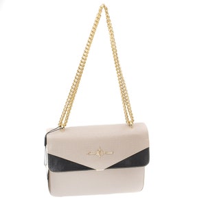 May include: A beige and black shoulder bag with a gold chain strap. The bag has a flap closure and a small logo on the front that says "Anna &  Eva."
