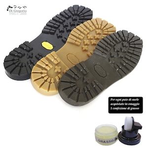 Könnte beinhalten: Drei verschiedene Schuhsohlen, eine schwarze, eine braune und eine beige, mit einem kleinen Glas Schuhcreme und einem Pinsel. Der Text auf dem Glas lautet "GRASSO". Der Text auf dem Bild lautet "Per ogni paio di suole acquistate in omaggio 1 confezione di grasso".