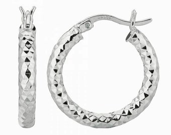 May include: A pair of silver hoop earrings with a textured diamond pattern. The earrings are approximately 1 inch in diameter.