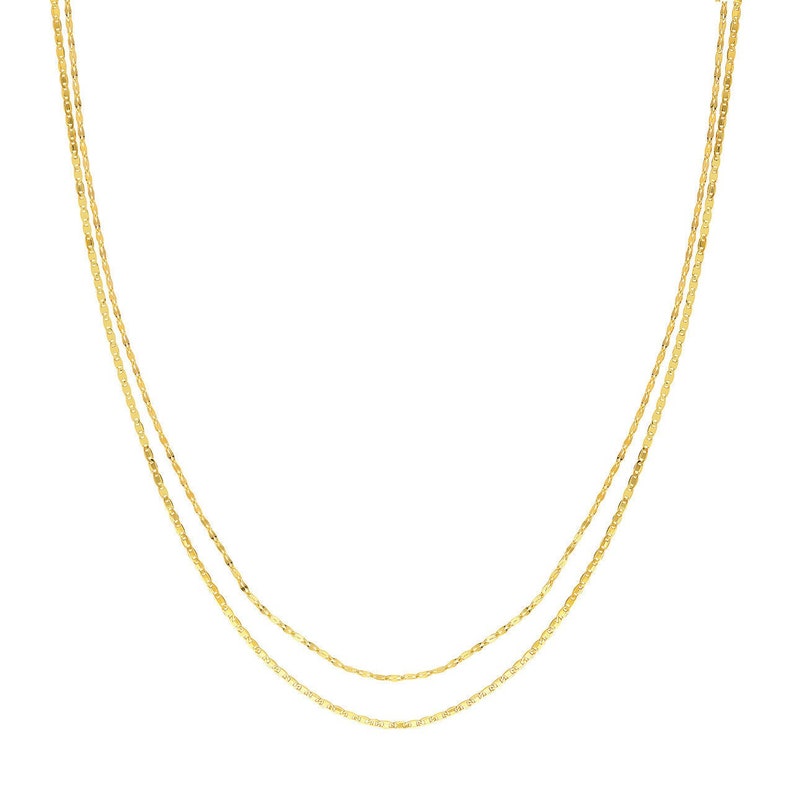 May include: A gold chain necklace with two strands of delicate, linked chain.