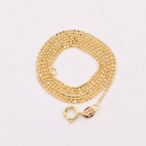 Op de afbeelding: Een gouden ketting met een delicaat, parelmoer ontwerp. De ketting is ongeveer 45 cm lang en heeft een karabijn sluiting.