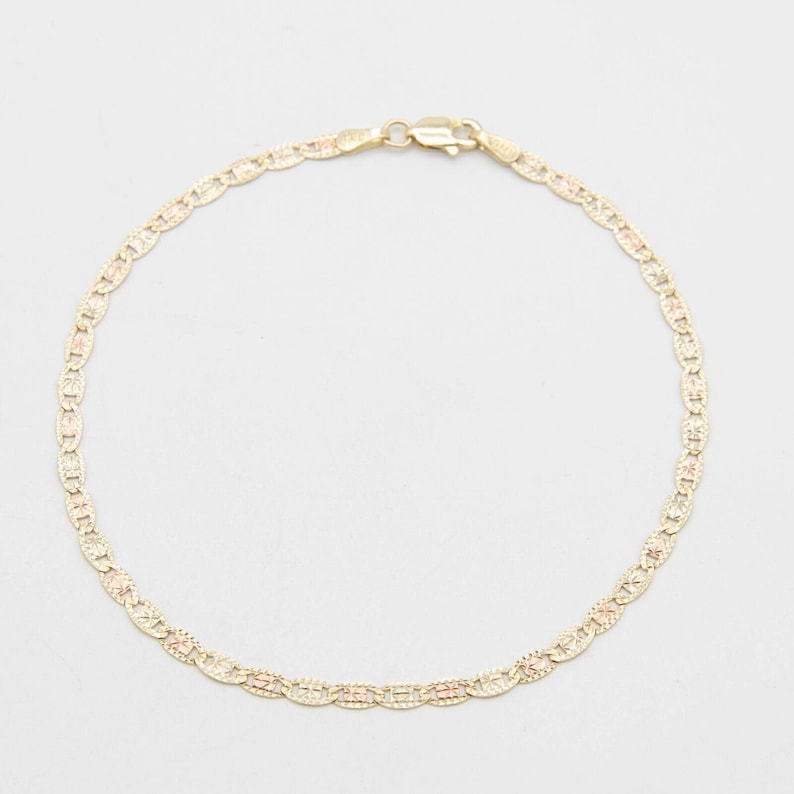 K&ouml;nnte beinhalten: Ein goldenes Kettenarmband mit einem zarten, gemusterten Design. Das Armband ist aus zweifarbigem Gold gefertigt, mit einer gelbgoldenen Basis und ros&eacute;goldenen Akzenten.