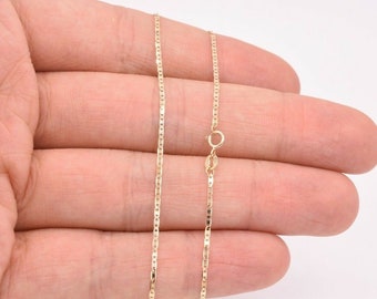 May include: A gold chain necklace with a lobster clasp. The chain is a delicate, thin, and flat design.